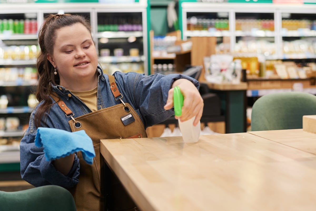 A smiling young woman with a disability working independently in a supermarket